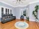 Spacious living room with hardwood floors, plantation shutters, and a comfortable leather sofa at 1403 W Watrous Ave, Tampa, FL 33606