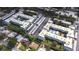 Aerial view showcases two apartment buildings with swimming pools, surrounded by lush trees and convenient parking areas at 1706 Belleair Forest Dr # 336, Belleair, FL 33756