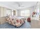 Bright bedroom featuring a floral-patterned bed, ceiling fan, and ample natural light from the window at 1706 Belleair Forest Dr # 336, Belleair, FL 33756