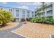 Landscaped common grounds, featuring tropical plants, gravel pathways, and seating to enjoy the outdoor space at 1706 Belleair Forest Dr # 336, Belleair, FL 33756