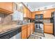 Traditional kitchen featuring wood cabinets, stainless steel appliances, and a convenient dishwasher at 1706 Belleair Forest Dr # 336, Belleair, FL 33756
