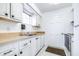 Well-lit kitchen featuring white cabinets, stainless steel sink and appliances, and a window for natural light at 1706 Belleair Forest Dr # 336, Belleair, FL 33756