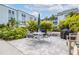 Community patio area with dining set, perfect for relaxing and grilling amidst lush tropical landscaping at 1706 Belleair Forest Dr # 336, Belleair, FL 33756