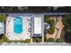 Aerial perspective of a luxurious pool area with sun loungers and tables, set amid lush tropical landscaping at 1706 Belleair Forest Dr # 336, Belleair, FL 33756