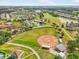 Aerial view of a residential community featuring a baseball field, walking paths, and lush landscaping at 1805 Granville Ln, Sun City Center, FL 33573