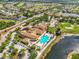 Aerial view of a clubhouse featuring a pool, golf course, and lush landscaping, with surrounding residential community at 1805 Granville Ln, Sun City Center, FL 33573
