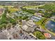 Aerial view of community center with multiple tennis courts, a parking lot, and lush landscaping at 1805 Granville Ln, Sun City Center, FL 33573