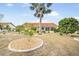 Beautifully landscaped backyard featuring a spacious lawn and tropical plants and trees, with a screened-in lanai at 1805 Granville Ln, Sun City Center, FL 33573