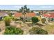Aerial view of backyard featuring a spacious lawn with landscaped flowerbeds and tropical trees with a screened-in lanai at 1805 Granville Ln, Sun City Center, FL 33573