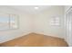 A bright bedroom with wood floors, two windows, and a double-door closet at 1805 Granville Ln, Sun City Center, FL 33573