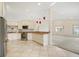 Open kitchen with stainless steel appliances, granite countertops, tile backsplash, and an open view to the living room at 1805 Granville Ln, Sun City Center, FL 33573