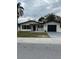 Single-story home featuring a well-manicured lawn and an attached garage at 1809 Driftwood N Cir, Oldsmar, FL 34677