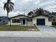 Charming single-story home featuring a well-manicured lawn and an attached garage at 1809 Driftwood N Cir, Oldsmar, FL 34677