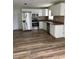 Kitchen with stainless steel appliances, white cabinets and wood-look floors at 1809 Driftwood N Cir, Oldsmar, FL 34677