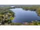 Aerial view displays a lakefront property with mature trees and a lake and a private dock in a nature preserve at 18132 Oakdale Rd, Odessa, FL 33556