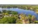 Aerial view shows lakefront home nestled among mature trees on a sprawling lake, providing stunning natural views at 18132 Oakdale Rd, Odessa, FL 33556