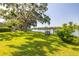 Lush backyard with mature trees, leading to a tranquil lake and private wooden dock at 18132 Oakdale Rd, Odessa, FL 33556