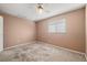 A bright bedroom featuring neutral walls, carpeted floors, and a ceiling fan at 18132 Oakdale Rd, Odessa, FL 33556