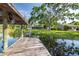 Waterfront home features a covered dock leading to the main house with beautiful landscaping and mature trees at 18132 Oakdale Rd, Odessa, FL 33556