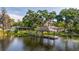 Beautiful lake view with a gazebo-covered dock, a screened-in porch, and mature trees with Spanish moss at 18132 Oakdale Rd, Odessa, FL 33556