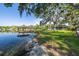 Lakeside home with expansive lawn shaded by mature trees with a gazebo style dock in a charming lake community at 18132 Oakdale Rd, Odessa, FL 33556