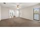 Spacious living room with carpet, ceiling fan, and an open layout to another room at 18132 Oakdale Rd, Odessa, FL 33556