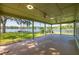 Spacious screened-in patio with lake views, ceiling fans, and an area for outdoor relaxation at 18132 Oakdale Rd, Odessa, FL 33556