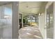 A screened-in porch with concrete flooring, looking out to a fenced yard and lake at 18132 Oakdale Rd, Odessa, FL 33556
