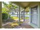 Screened-in porch overlooking a tranquil lake with a dock, lush landscaping, and mature trees at 18132 Oakdale Rd, Odessa, FL 33556