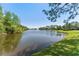 Scenic lake view with a fountain, lush greenery, and clear blue sky. Relaxing waterfront community living at 19117 Centre Rose Blvd, Lutz, FL 33558