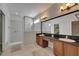 Bathroom featuring a double vanity, large mirror, and tiled shower at 21744 Waverly Shores Ln, Land O Lakes, FL 34637