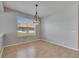 Open dining room with wood floors, pendant light, a large window, and light-colored walls at 21744 Waverly Shores Ln, Land O Lakes, FL 34637