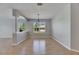 Open dining room with wood floors, decorative column, pendant light, and large window at 21744 Waverly Shores Ln, Land O Lakes, FL 34637