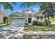 Charming single-story home with a well-manicured lawn, stone accents, and attached two-car garage at 21744 Waverly Shores Ln, Land O Lakes, FL 34637