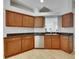 Well-lit kitchen with wood cabinetry, stainless steel dishwasher, granite countertops, and light wood flooring at 21744 Waverly Shores Ln, Land O Lakes, FL 34637