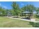 A shaded playground with a picnic table, playground equipment, and green grass is in the community park at 21744 Waverly Shores Ln, Land O Lakes, FL 34637