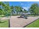 A playground has swings and slides available on top of wood chips in the community at 21744 Waverly Shores Ln, Land O Lakes, FL 34637