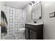 Cozy bathroom features a modern vanity, updated fixtures, and a shower/tub combo with decorative curtain at 26850 Middleground Loop, Wesley Chapel, FL 33544