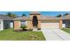 Charming single Gathering home with a two-car garage, lovely landscaping, and a well-manicured front lawn at 26850 Middleground Loop, Wesley Chapel, FL 33544