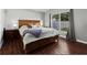 Cozy main bedroom with hardwood floors, a large window, and stylish decor at 26850 Middleground Loop, Wesley Chapel, FL 33544