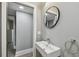 Stylish half-bathroom with a floating sink, round mirror and modern fixtures at 3411 N 12Th St, Tampa, FL 33605