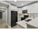 Contemporary kitchen with white cabinetry and black appliances, complemented by a view of hallway at 3411 N 12Th St, Tampa, FL 33605