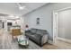 Comfortable living room featuring hardwood floors, grey sofa, glass table, and ceiling fan at 3411 N 12Th St, Tampa, FL 33605