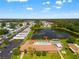 Panoramic aerial view of a community with a pond, fountain, pool, tennis court, and clubhouse on a sunny day at 34150 Estates Ln, Wesley Chapel, FL 33543