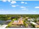 Overhead shot of a residential community with pool, shuffleboard courts, and a pond with a pier at 34150 Estates Ln, Wesley Chapel, FL 33543