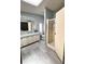 Bathroom featuring light blue walls, gray floors, and a tiled shower with glass doors at 34150 Estates Ln, Wesley Chapel, FL 33543