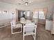 Cozy dining area with a round table and PVC frame chairs next to a well-lit window at 34150 Estates Ln, Wesley Chapel, FL 33543