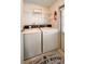 A utility room featuring a white washer and dryer, shelving, a fire extinguisher, and 