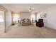 Bright living room showcasing cozy furniture, neutral carpet, ceiling fan and views to the exterior through the windows at 34150 Estates Ln, Wesley Chapel, FL 33543