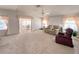 Spacious living room featuring neutral carpeting, comfortable seating, and abundant natural light from the large windows at 34150 Estates Ln, Wesley Chapel, FL 33543